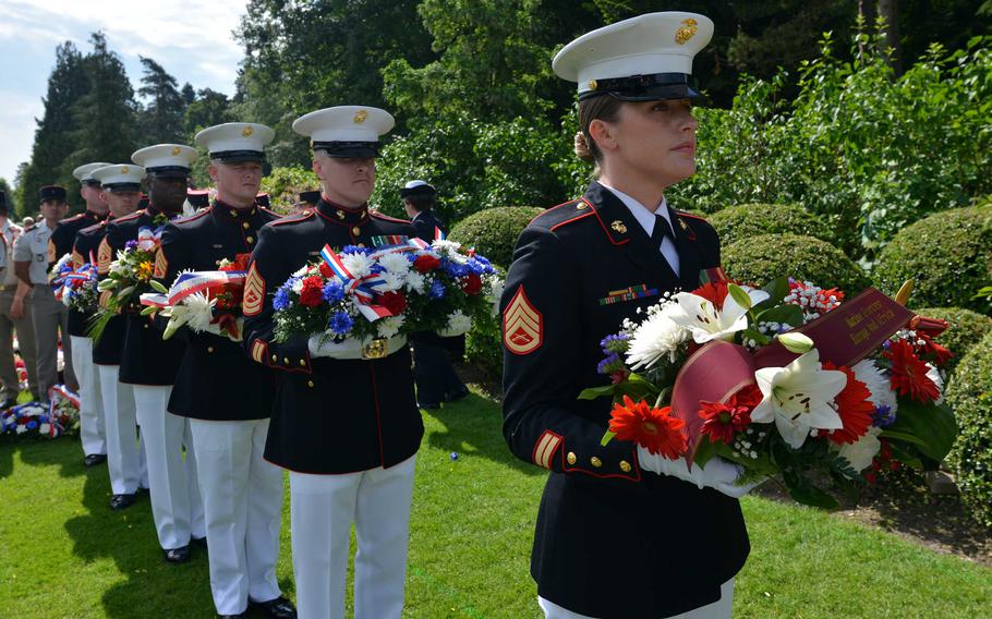 Marines in dress uniform hold wreaths at a Memorial Day ceremony.