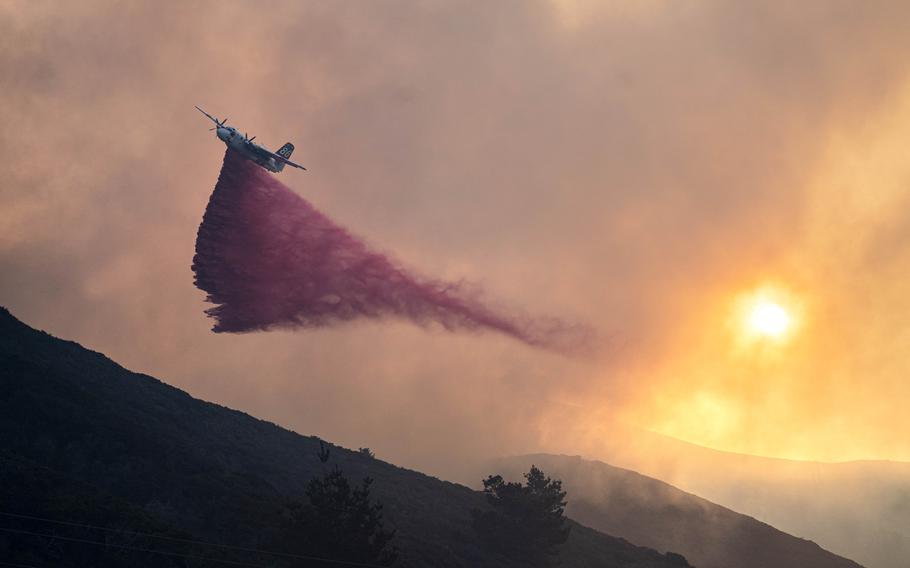 An aircraft distributes fire retardant and water to support Big Sur Fire and CalFire firefighters from nearby areas in battling the Colorado Fire in Big Sur, Calif., on Jan. 22, 2022.