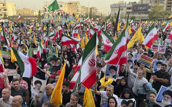 Protestors carry Iranian national flags and posters of the late revolutionary founder Ayatollah Khomeini and Supreme Leader Ayatollah Ali Khamenei, while chanting anti U.S. and Israel slogans, in Tehran, Iran, Tuesday, June 24, 2025. (AP Photo/Vahid Salemi)