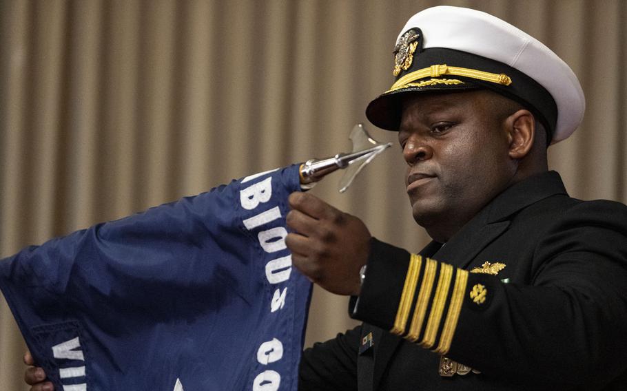 Capt. Atim D. Senthill, commanding officer of Amphibious Construction Battalion 2, retires the command flag during Thursday's decommissioning ceremony at Joint Expeditionary Base Little Creek.