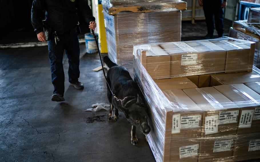 A U.S. Customs and Border Protection (CBP) officer and a K-9 inspect good from a truck at the Laredo Port of Entry in Laredo, Texas, on Jan. 14, 2022. 