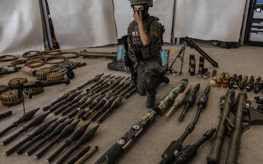 An Israeli officer, identified as Major G. under briefing ground rules, shows a cache of confiscated Hamas weapons at a military base in southern Israel on Oct. 20, 2023.