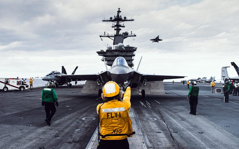 A sailor handles an F-35C Lightning II from Strike Fighter Squadron 147 on the flight deck of the aircraft carrier USS George Washington Dec. 5, 2023.
