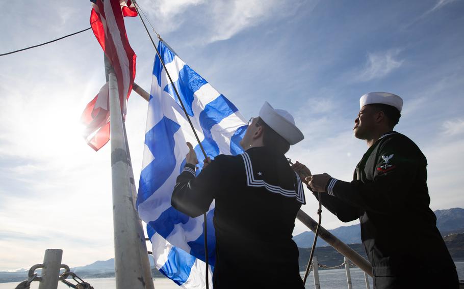 Seaman Daniel Mitchell and Petty Officer 3rd Class Nicholas Reed raise the American and Greek flags aboard USS Gerald R. Ford during the aircraft carrier's port visit to Souda Bay, Greece, Dec. 2, 2023.