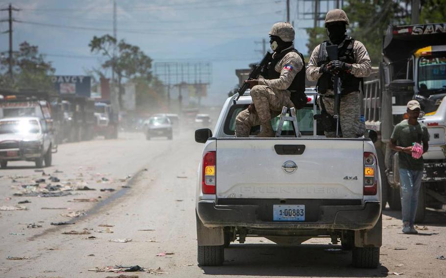 Haiti police on patrol keep their eyes on traffic during a stop at a police checkpoint in Tabarre, near the U.S. Embassy, just east of metropolitan Port-au-Prince. Gangs have taken control of neighborhoods in the vicinity.