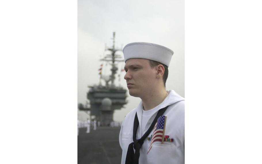 Petty Officer 3rd Class Rodney Bundy, from St. Paul, Minn., stands at attention as the Kitty Hawk pulls in to its home port Tuesday morning, May 6, 2003.