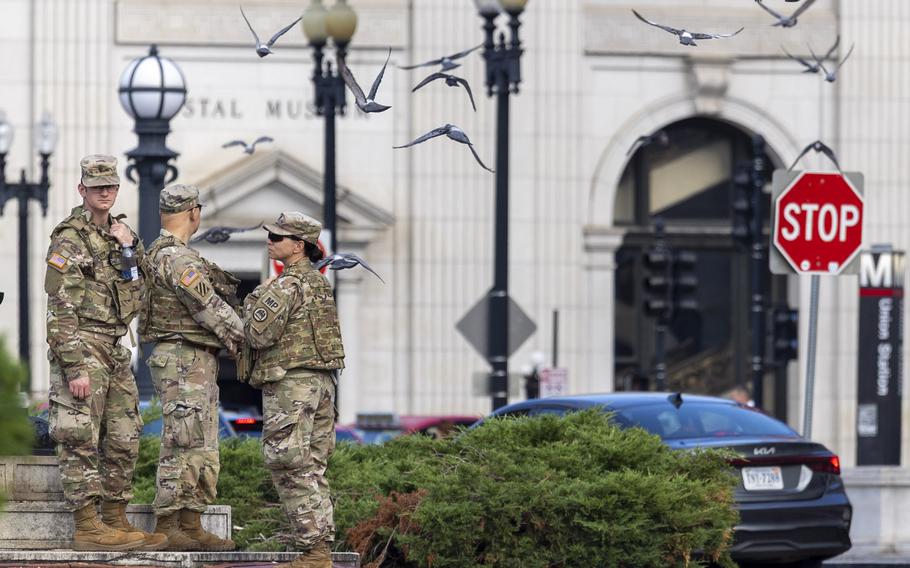 Three soldiers standing outside.