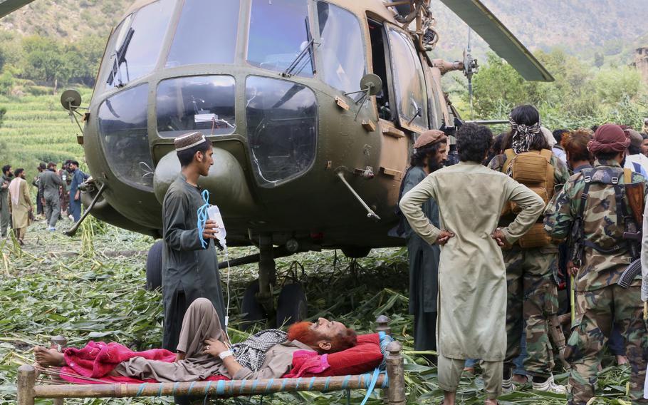 Injured people are prepared to board a military helicopter.