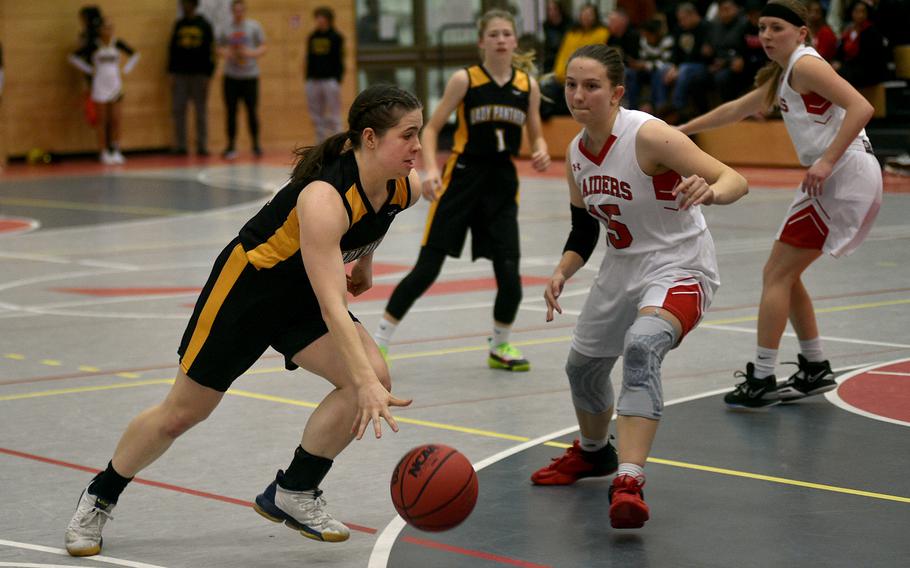 Stuttgart's Bella Henderson, left, drives against Kaiserslautern's Elizabeth Marriott on Friday evening at Kaiserslautern High School in Kaiserslautern, Germany. In the background are Stuttgart's Haley Wells, center, and Kaiserslautern's Lena Herrmann.