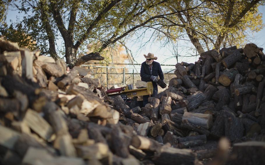 A worker splits wood at Zia Firewood in Albuquerque, N.M.