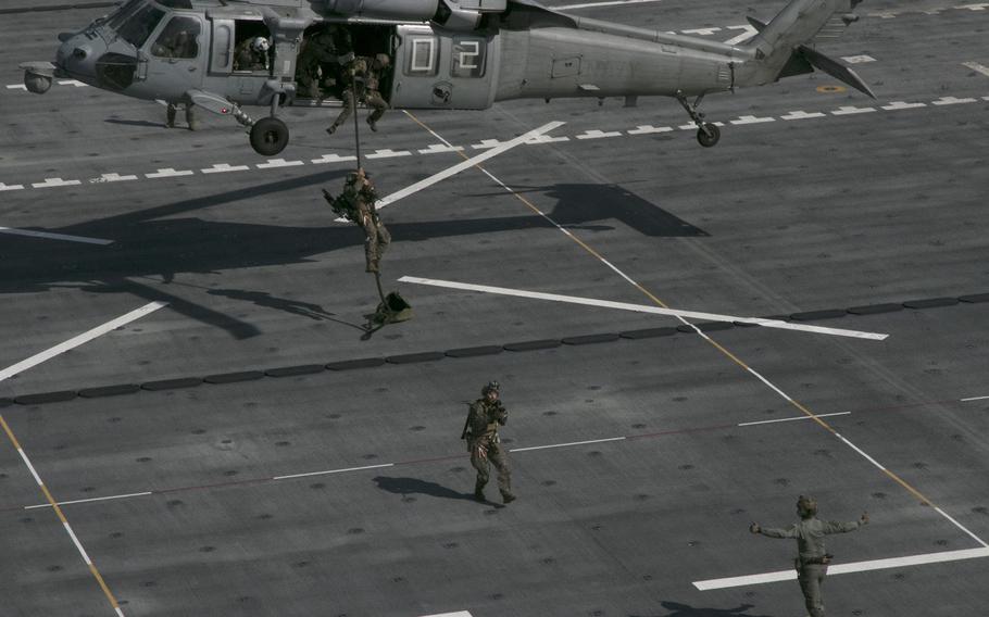 Members of the 31st Marine Expeditionary Unit fast-rope onto the USS Miguel Keith during visit, board, search and seizure training, part of the Noble Fusion exercise, in the East China Sea, Feb. 5, 2022. 