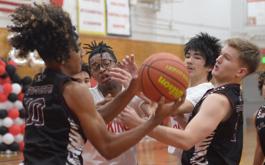 Matthew C. Perry's Shion Fleming and Ryan Livengood and E.J. King's Keith Lombard and Nolan FitzGerald tangle for the ball during Friday's DODEA-Japan boys basketball game. The Cobras won 57-53.