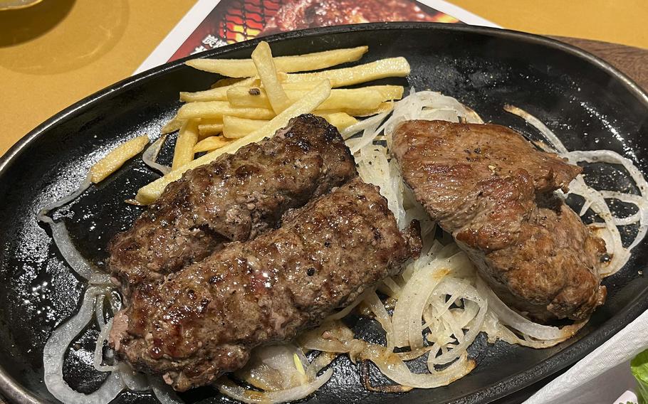 Steaks and hamburgers are cooked on a blazing charcoal-flame grill near the front of Bronco Billy Steak House.