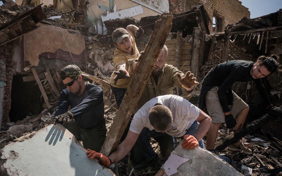 Volunteers on May 3 clear an area of Kharkiv, Ukraine, that was destroyed in a strike. 