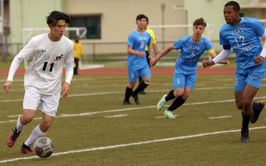 E.J. King's Joseph Barrett looks to send the ball upfield against Osan during Monday's Division II boys soccer match. The Cobras won 4-0.