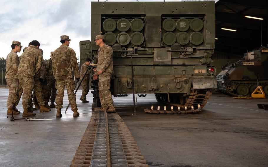 Soldiers assigned to 1st Battalion, 6th Field Artillery Regiment take a break while replacing the track of an Multiple Launch Rocket System in Grafenwoehr, Germany, on Feb. 1, 2024. 