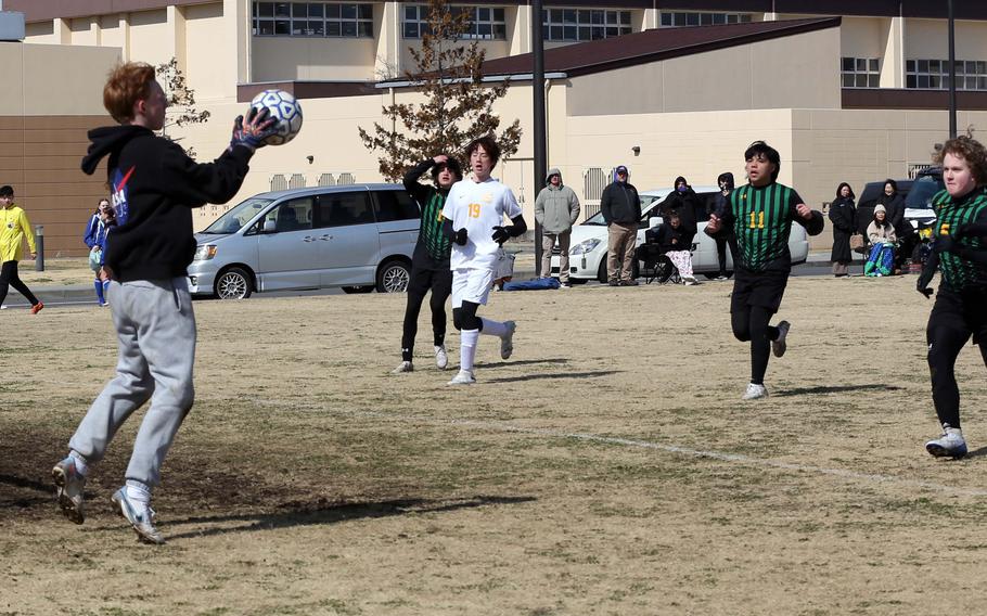 Yokota goalkeeper Cooper Gaulin stops a shot as Robert D. Edgren's Ethan Young and Rain Rodriguez close in on the net during Saturday's DODEA-Japan boys soccer match. The Panthers won 2-0.