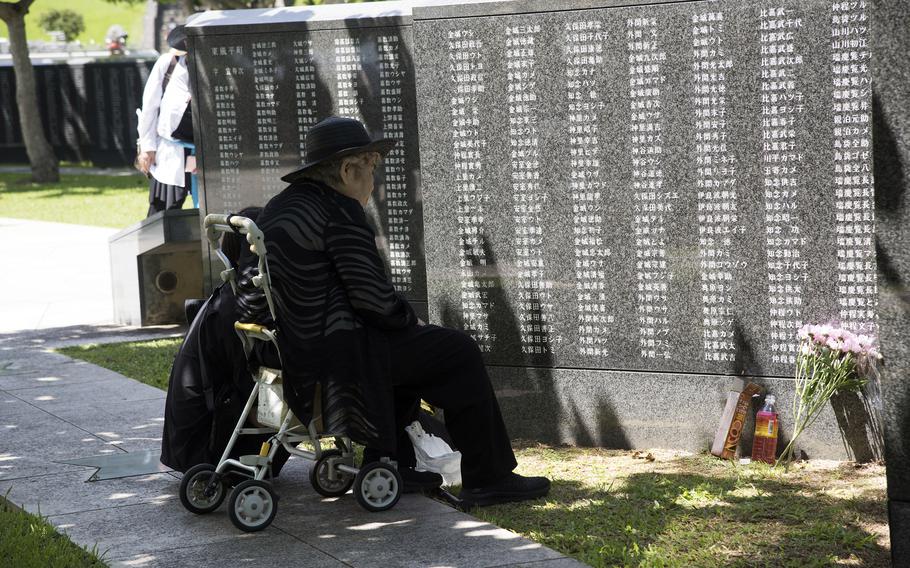 A woman looks at names on the Cornerstone of Peace monument.