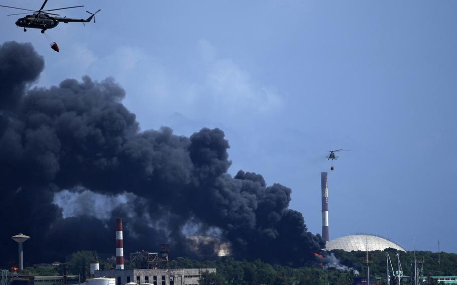 Helicopters hauling water fly over the Matanzas Supertanker Base, as firefighters and specialists work to quell the blaze which began during a thunderstorm the night before, in Matazanas, Cuba, Saturday, Aug. 6, 2022. Cuban authorities say lightning struck a crude oil storage tank at the base, causing a fire that led to four explosions which injured more than 50 people.