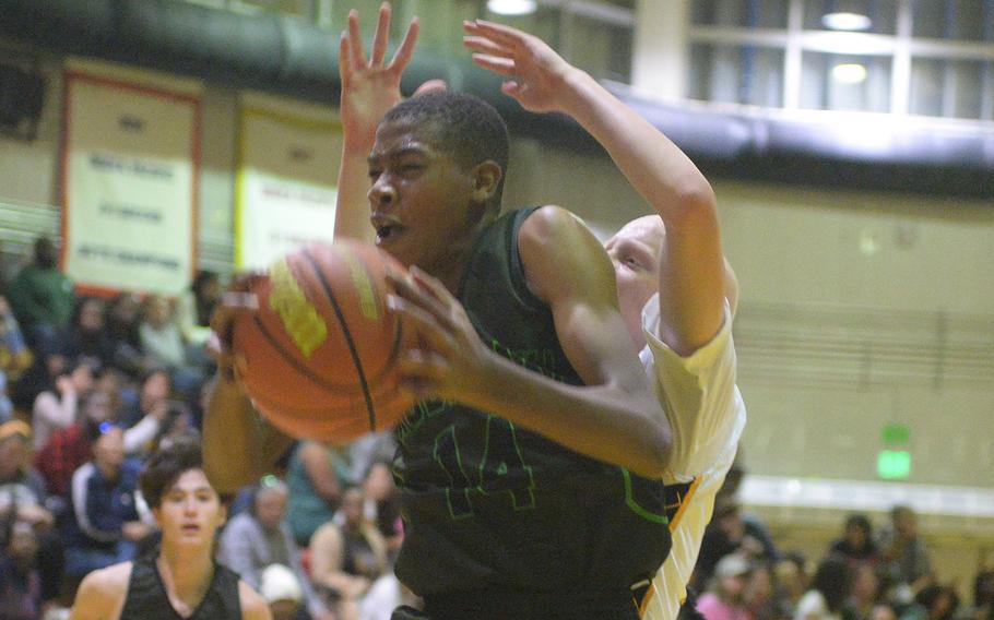 Kubasaki's Alex James snags a rebound in front of Kadena's Drew Eaglin during Friday's DODEA-Okinawa boys basketball game. The Panthers won 58-29, improving to 3-0 against the Dragons this season.