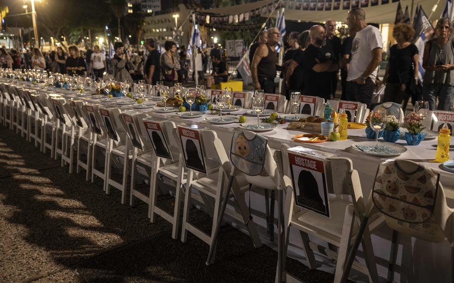 A Shabbat table with empty chairs, including ones for children, represent the hostages in Gaza during a protest in Tel Aviv on Oct. 21, 2023. 
