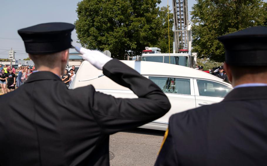 A hearse carrying the body of Marine Corps Cpl. Humberto "Bert" Sanchez passes during his funeral procession at the corner of 8th Street and East Market Street on Sept. 12, 2021, in Logansport, Ind.