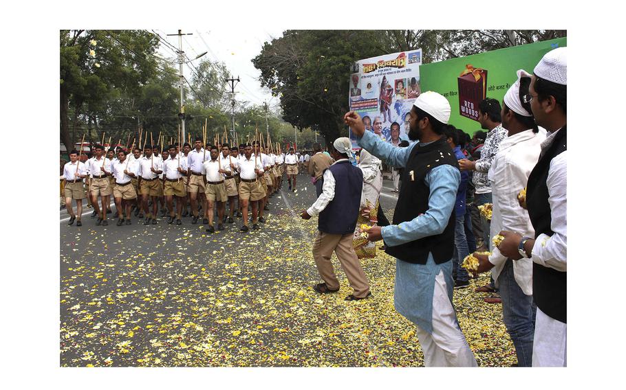 Indian Muslims shower flower petals as volunteers of Hindu nationalist group Rashtriya Swayamsevak Sangh, (RSS), march on the concluding day of their three-day meeting in Bhopal, India, on Feb. 23, 2014. 