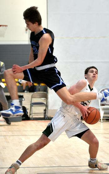 Naples' Patrick Fraim, right, ducks as Rota's Hampton Brasfield jumps by during pool play of the Division II DODEA Eueopean Basketball Championships on Wednesday at Southside Fitness Center on Ramstein Air Base, Germany.