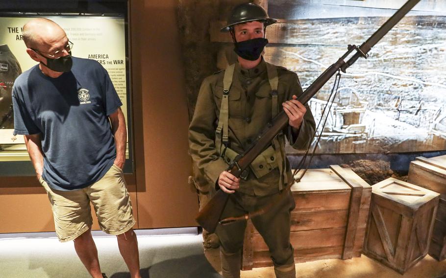 A soldier with a World War I uniform and weapon talks with visitors to the National Museum of the United States Army on its reopening day, June 14, 2021.