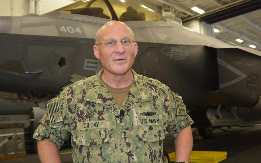 Adm. Michael Gilday, chief of naval operations, talks with reporters in the hangar deck of the USS Carl Vinson on Aug. 14, 2021.