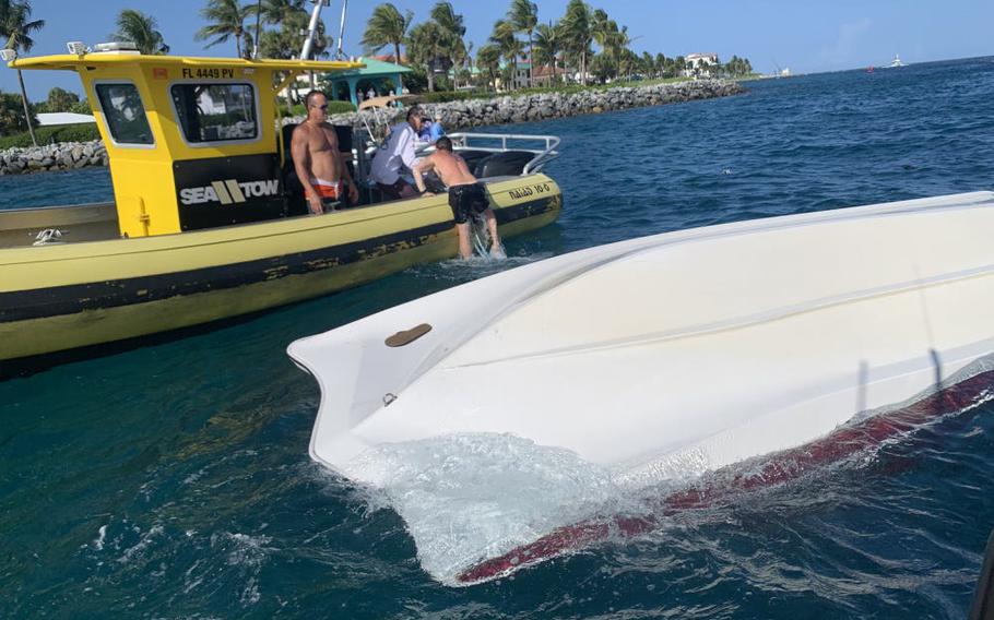 A commercial salvage boat crew rescues a boater from the water after a vessel overturned near Lake Worth Inlet on Aug. 1, 2021. A U.S. Coast Guard Station Lake Worth Inlet boat crew, a commercial salvage boat crew and good Samaritans rescued nine people after their vessel overturned.
