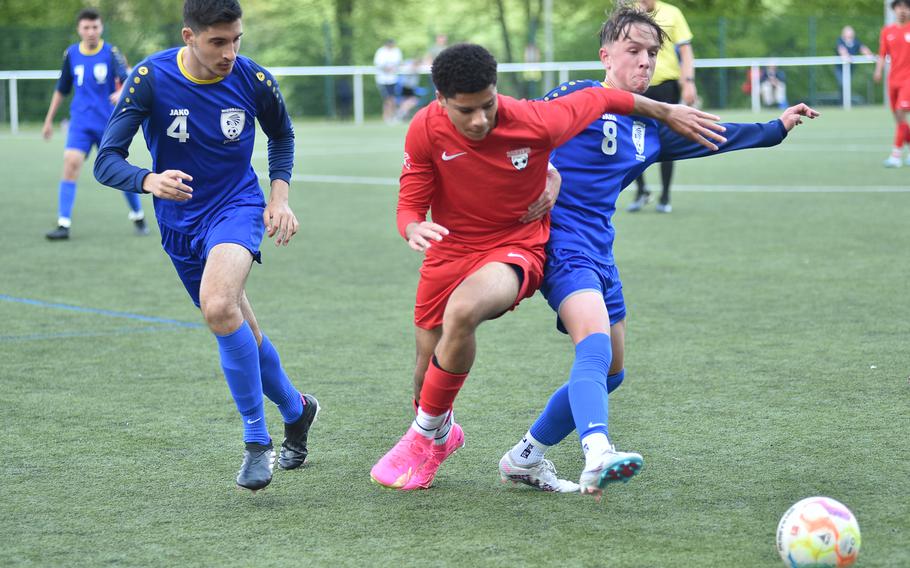 Kaiserslautern’s Aaron Zamor, center, and Wiesbaden’s Sean Heeter fight for the ball during pool-play action on May 15, 2023, in Reichenbach-Steegen, Germany. At left is the Warriors’ Michael Friel.