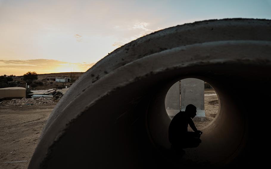 Mohammad Qeeran uses a concrete pipe as a makeshift bomb shelter in the Bedouin village of Sawa.