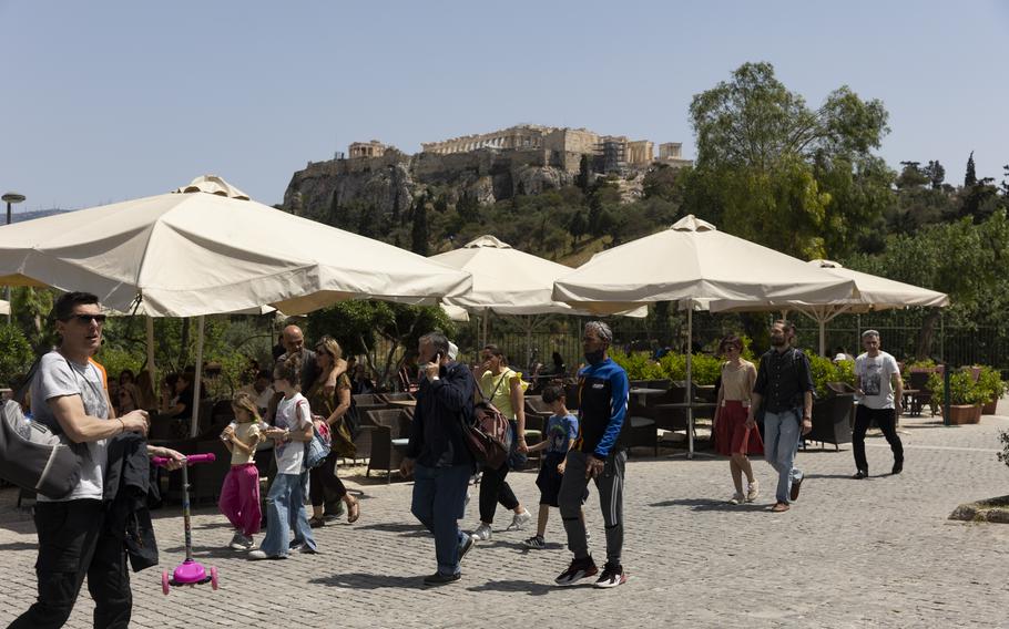 People make their way on a pedestrian street at the foot of the Acropolis hill, in Athens, on Sunday, May 1, 2022. Italy and Greece relaxed some COVID-19 restrictions on Sunday, in a sign that life was increasingly returning to normal before Europe's peak summer tourist season. 