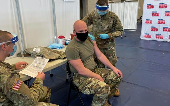 Indiana National Guard Sgt. Abigail Gates administers a COVID vaccination shot Wednesday, Dec. 16, 2020 in Franklin, Indiana, to Sgt. 1st Class Ben Cripe. 