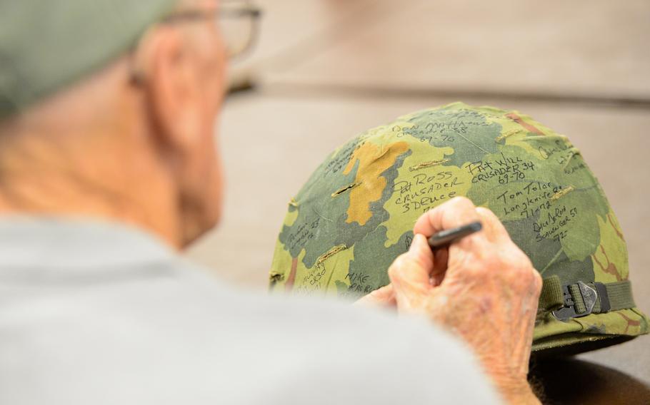 A man signs a helmet.