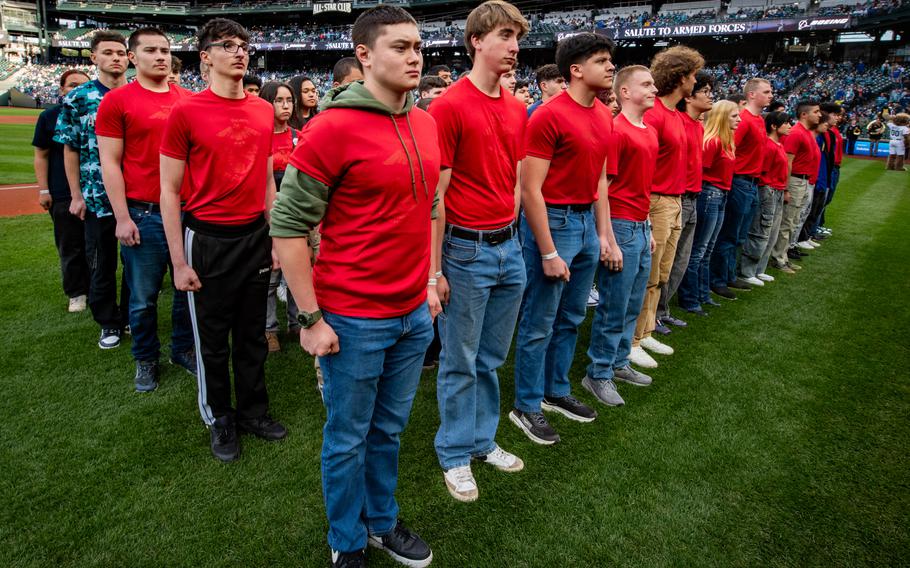 Future service members stand in formation on a baseball field