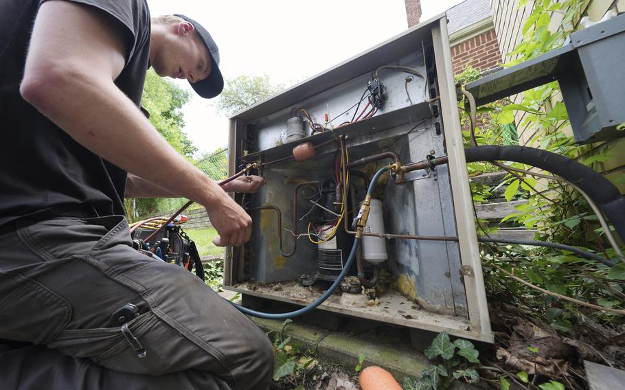 A technician works on an air conditioner.