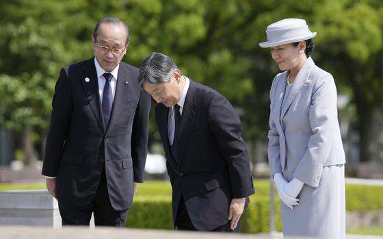 Japanese Emperor Naruhito, center, and Empress Masako bow in front of the cenotaph dedicated to the victims of the atomic bombing as they visit the Peace Memorial Park in Hiroshima, western Japan Thursday, June 19, 2025. Hiroshima Mayor Kazumi Matsui is at left. (Kai Naito/Kyodo News via AP)