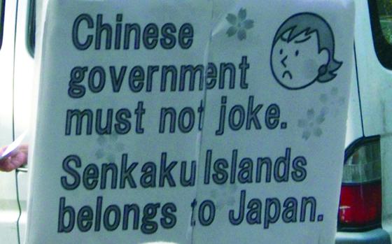 A Japanese citizen holds up a sign protesting the Chinese government's claim of ownership of the Senkaku Islands in this undated photo.