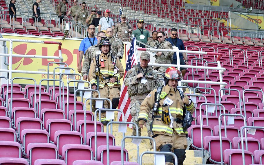 American firefighters and service members climb down the steps of the east stand at Fritz Walter Stadium on Sept. 11, 2023, in Kaiserslautern, Germany. Around 50 to 60 Americans and Germans participated in the 9/11 Stair Climb event.
