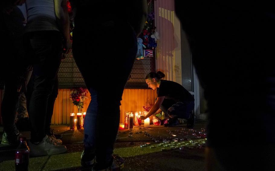 Autumn Piper lights candles during a vigil honoring Marcus Wilson, one of two men who were recently killed in the Highland town neighborhood of Baltimore in April. 