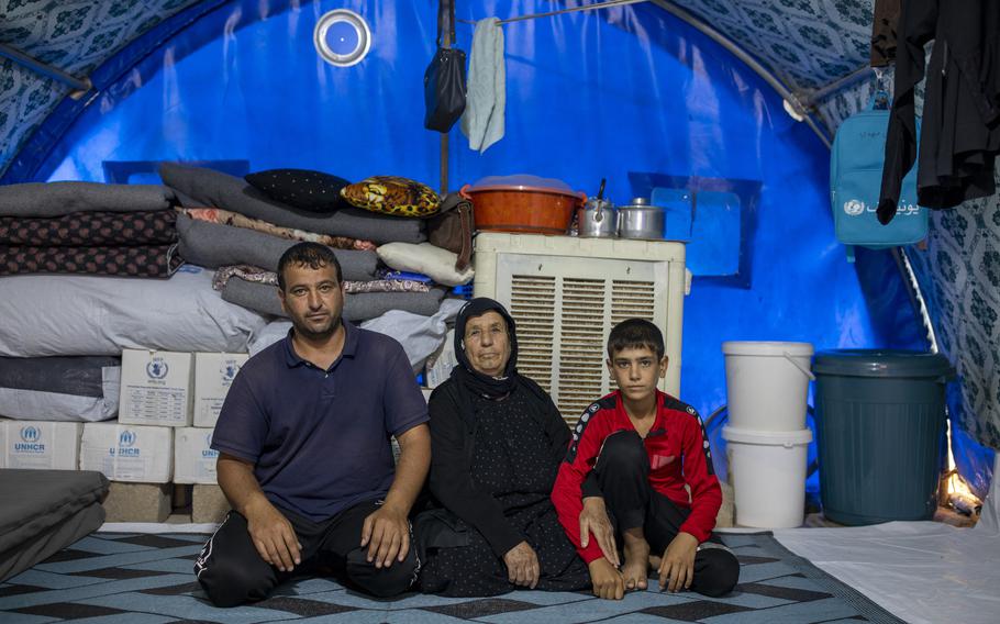 Alia Ibrahim, 65, of Tal Afar, with her son Hussein Mahmoud, 35, and grandson in her tent in the Jeddah camp. 
