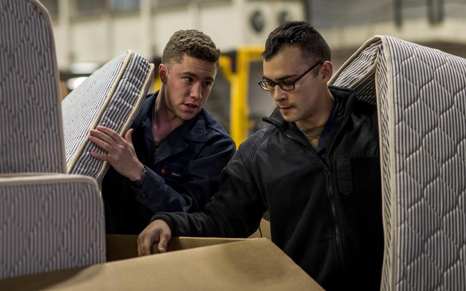 Seamen Jacob Gaudin, left, and Patrick Morel move mattresses aboard the aircraft carrier USS George H.W. Bush in the Atlantic Ocean in 2019. Uncomfortable mattresses and overwork remain an issue for the Navy as it seeks to resolve the ongoing problem of sailor fatigue, according to a new report by the General Accountability Office.
