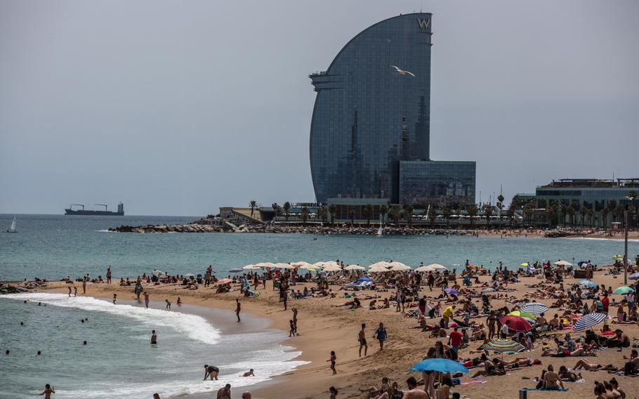 Vistors sunbathe on Barceloneta beach near the The W Hotel, operated by Marriott International Inc., in Barcelona, Spain, on June 5, 2021. 