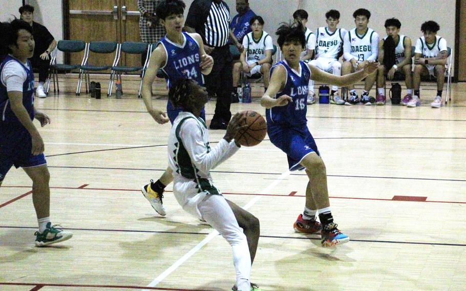 Daegu's Xavier Brown prepares to shoot against two Dwight School of Seoul defenders during Wednesday's Korea boys basketball game. The Warriors won their regular-season finale 60-35.
