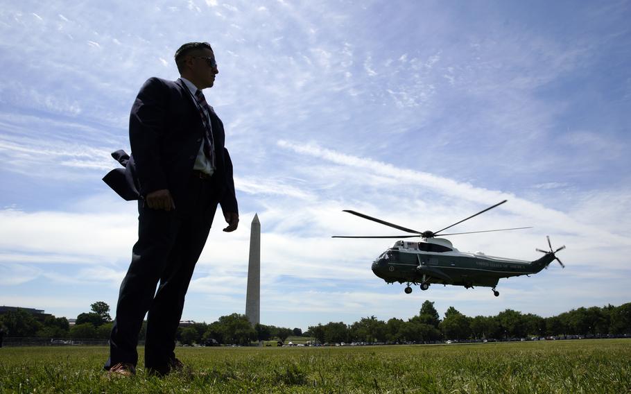 U.S. Secret Service stands guard as the Marine One helicopter, with President Joe Biden on board.