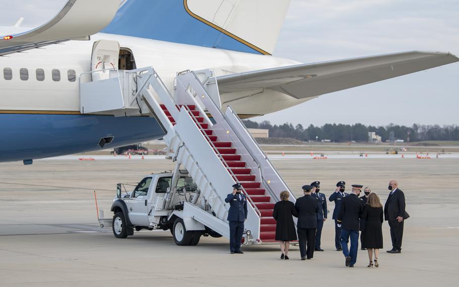 Chairman of the Joint Chiefs of Staff Gen. Mark Mille escorts Elizabeth Dole the wife of WWII veteran and former Kansas Sen. Bob Dole to a waiting Air Force transport plane on the tarmac at Joint Base Andrews, Md., on Friday, Dec. 10, 2021. At right, Army Maj. Garrett Beer escorts the Doles' daughter Robin.