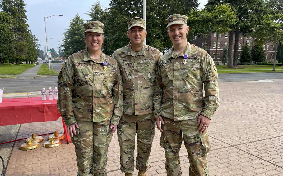 Army Sgt. 1st Class Andrea Hayden, left, and retired Maj. Patrick Sylvers, right, receive the Purple Heart on Sept. 11, 2022, at Joint Base Lewis-McChord, Wash., after surviving a missile attack on al Asad Air Base in Iraq in 2020. 