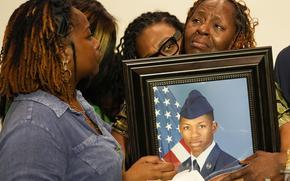 Chantemekki Fortson, mother of Roger Fortson, a U.S. Air Force senior airman, is comforted by family as she holds a photo of her son during a news conference regarding his death, along with family and Attorney Ben Crump, in Fort Walton Beach, Fla. Fortson was shot and killed by police in his apartment, May 3, 2024.